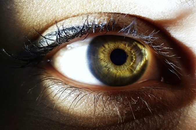 A closeup shot of the green eye of a woman