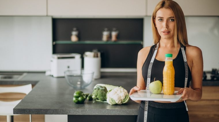 Young woman with measuting tape at the kitchen